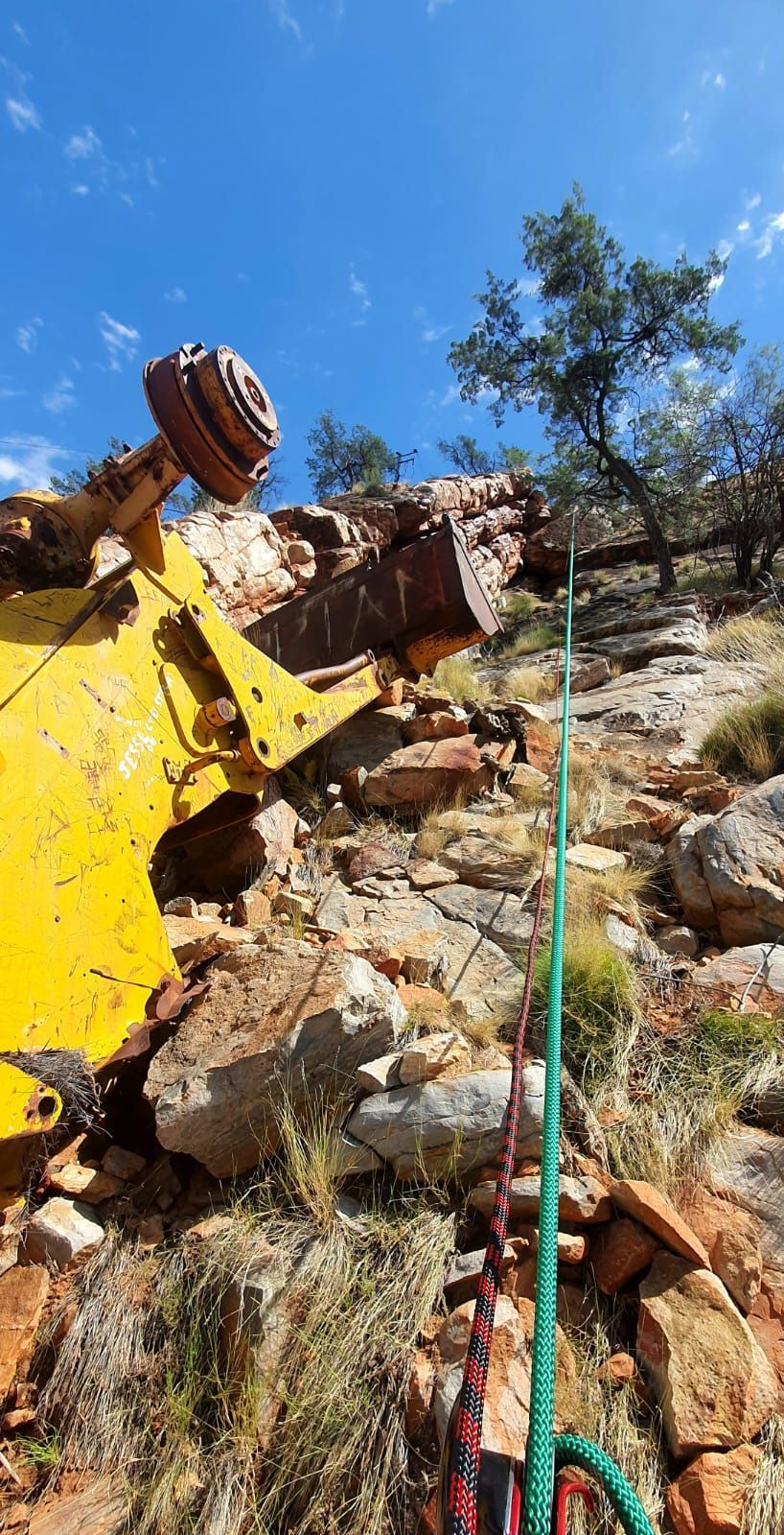 A yellow vehicle is sitting on top of a rocky hill.