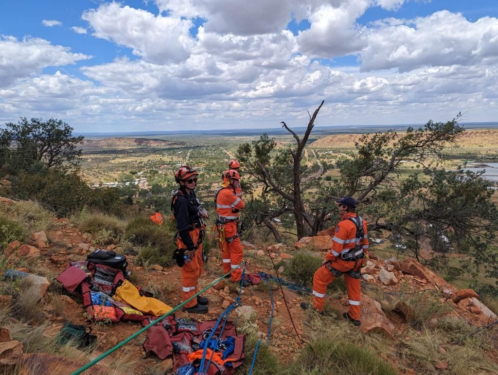 A group of firefighters are standing on top of a mountain.