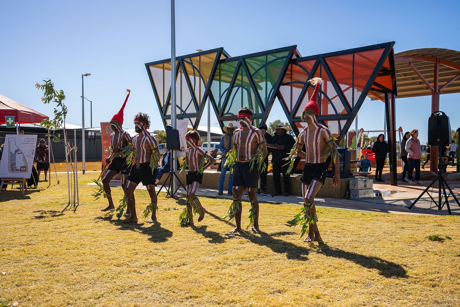 A group of people are dancing in a park.