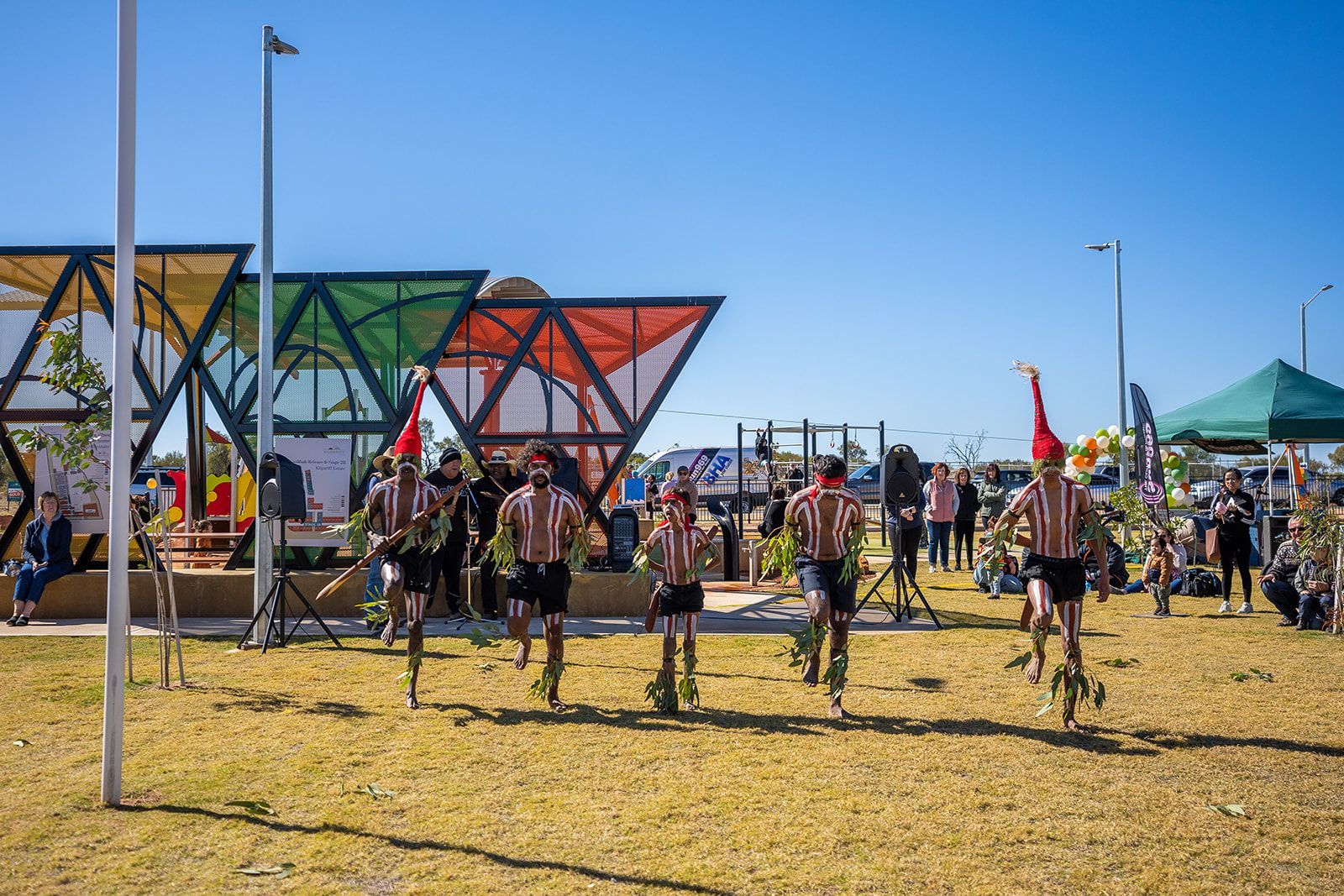 A group of people are dancing in a field.