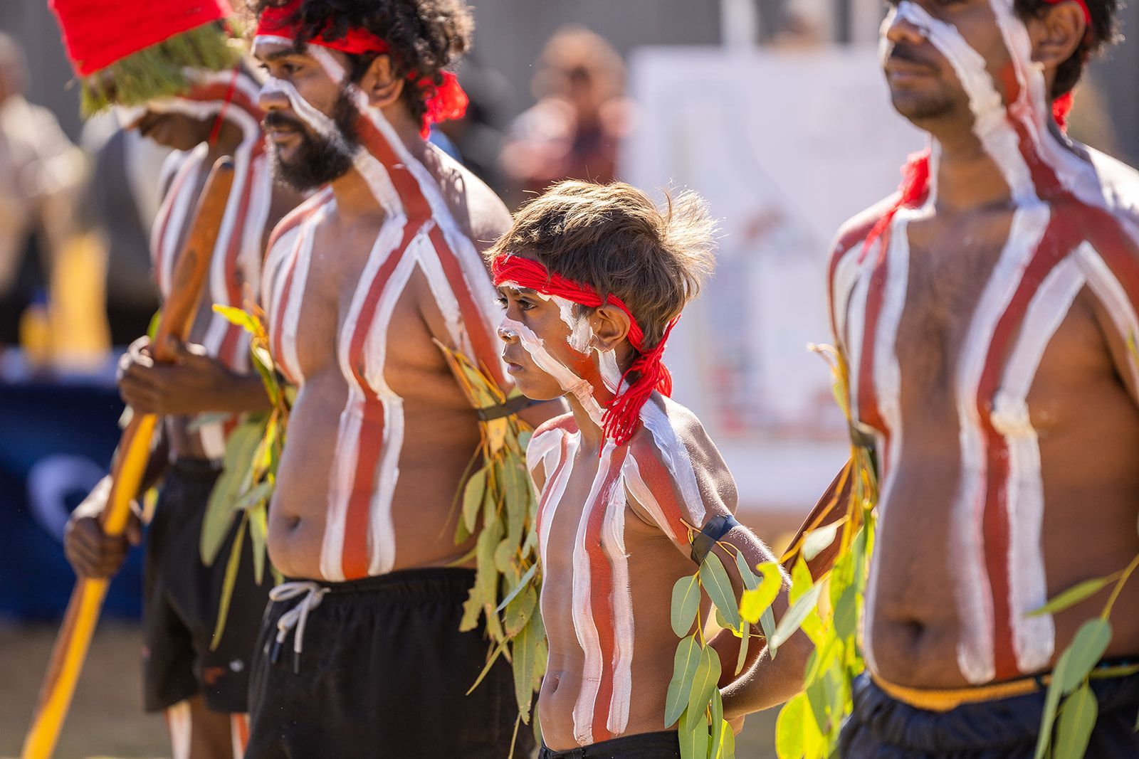 A group of people with their bodies painted in different colors are standing next to each other.