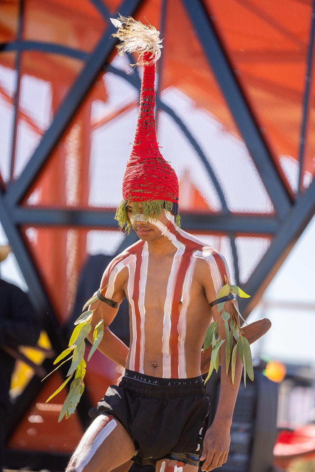 A man with red and white stripes on his body and a red hat on his head