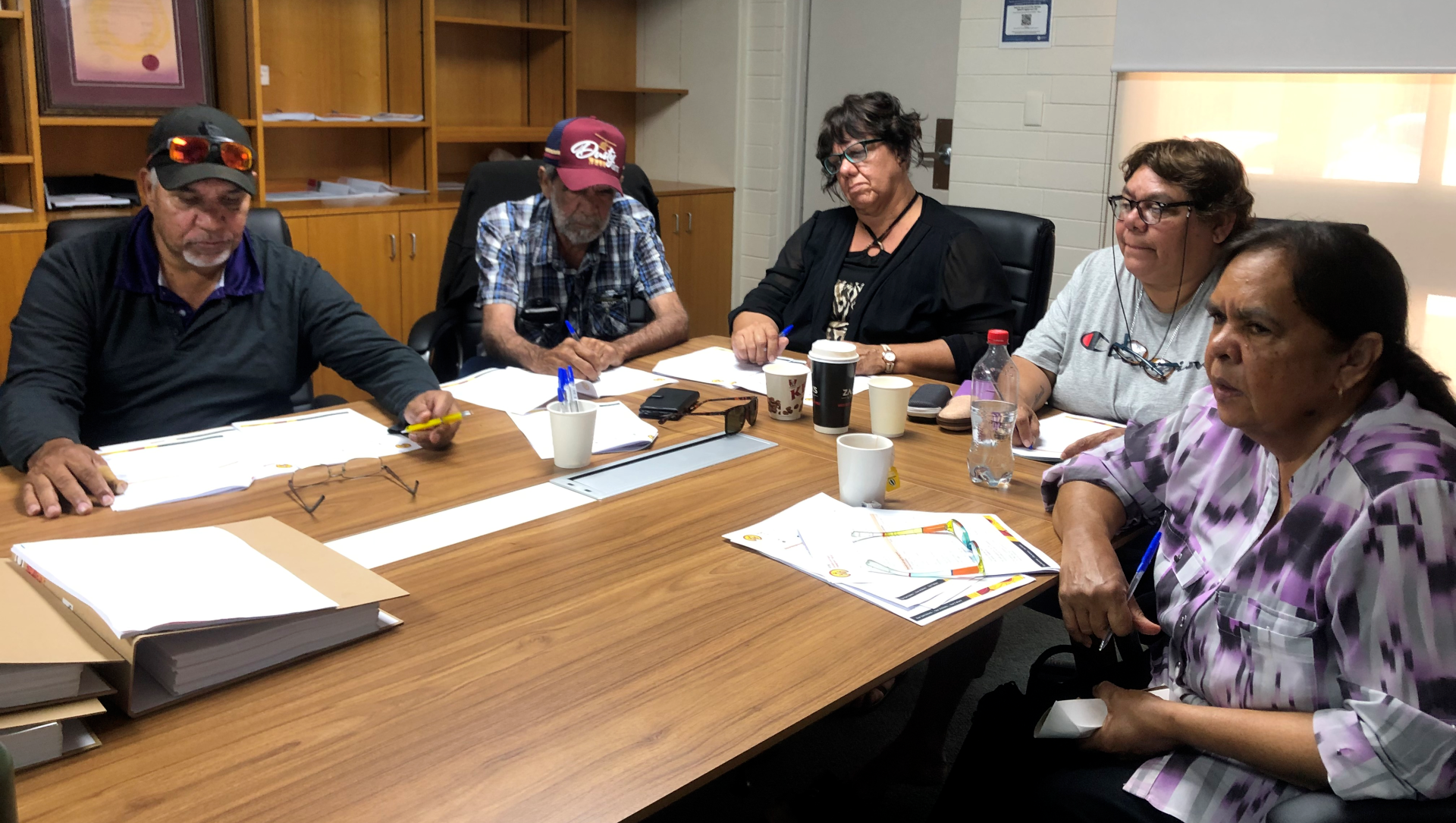 A group of people are sitting around a table having a meeting.