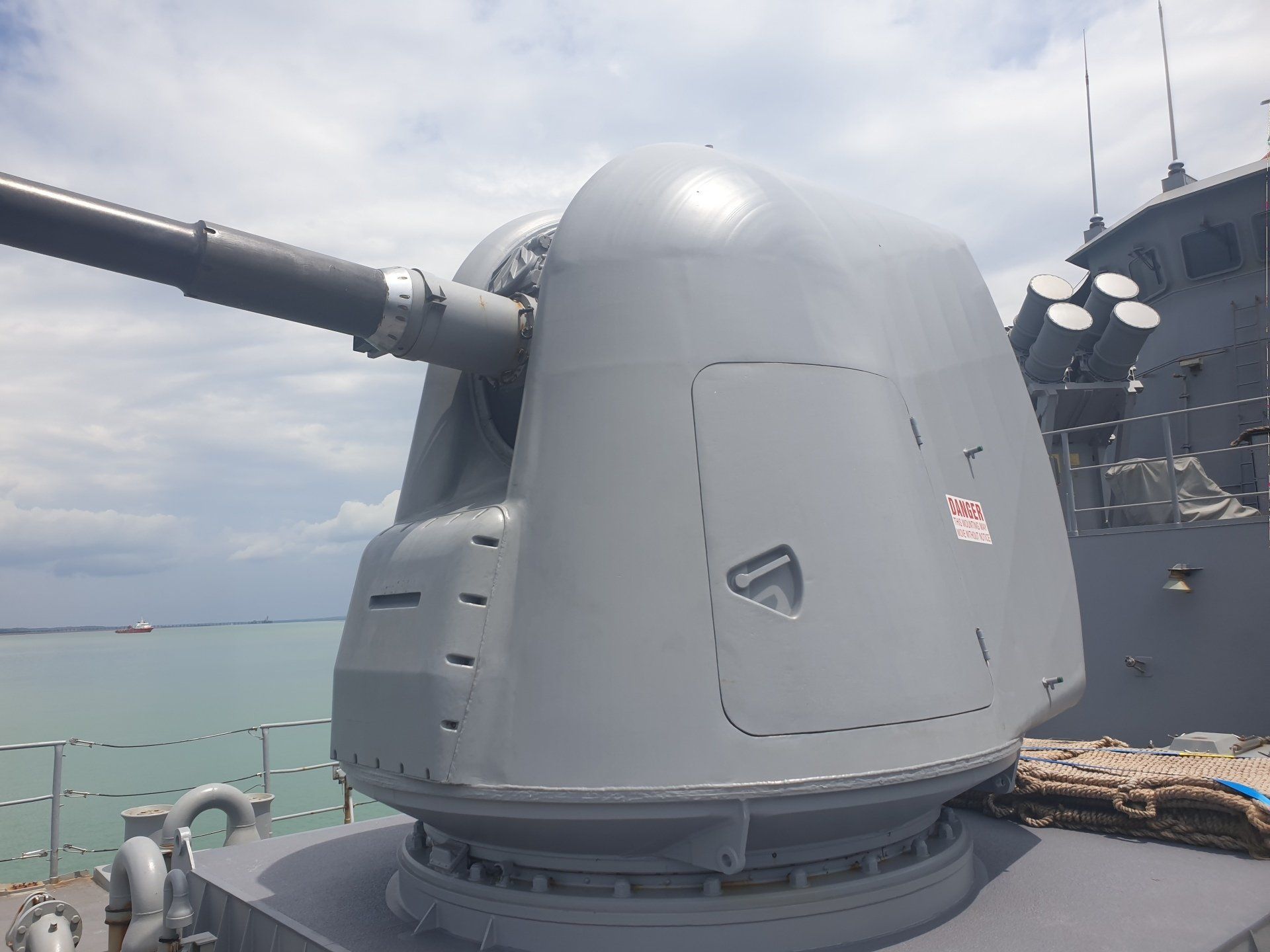 A large cannon on top of a ship with the ocean in the background