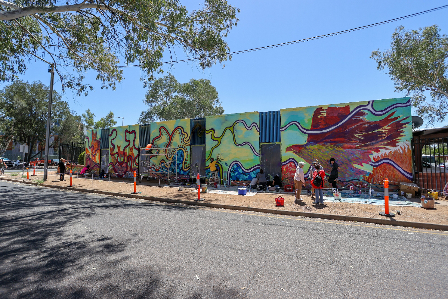 A group of people are painting a mural on the side of a building