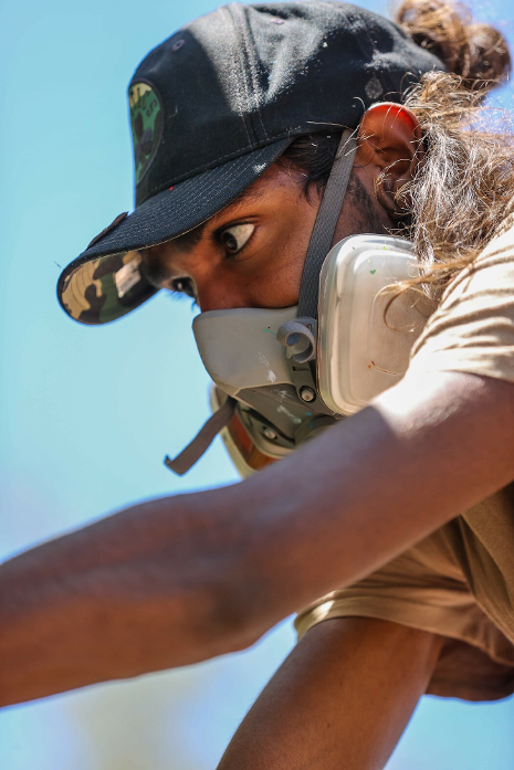 A man wearing a hat and a gas mask.