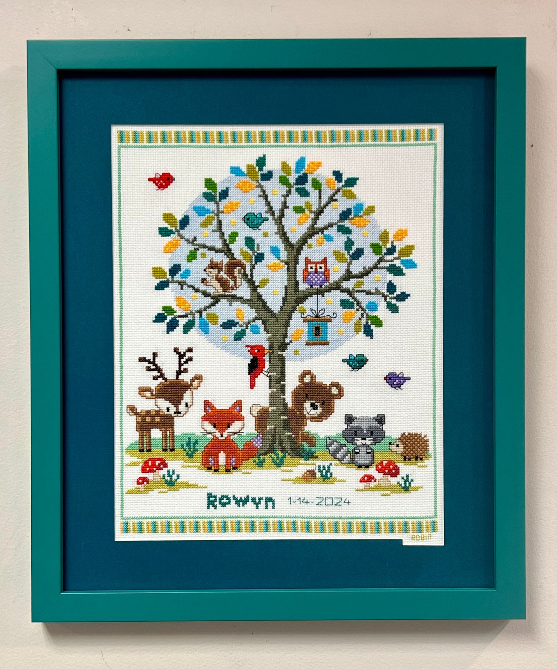 Two-story house with gray siding and garage doors, wet street reflects the evening sky.