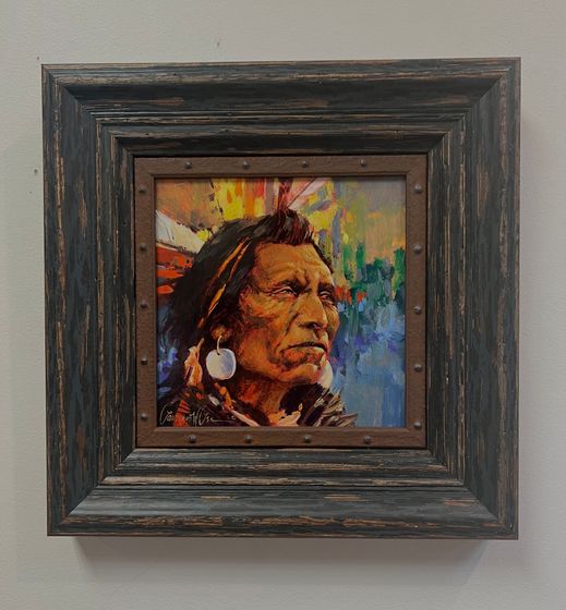 A white truck is parked in a parking lot next to a building.