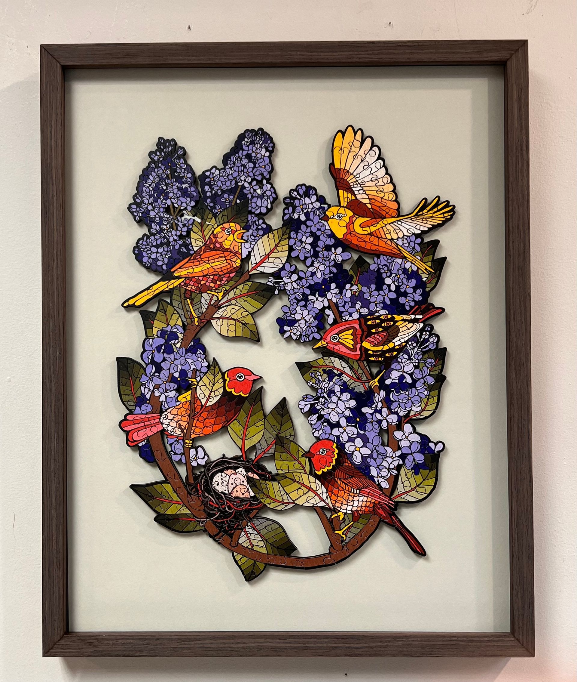 Framed artwork: Birds in a lilac bush, with purplish-blue flowers, flying, and reddish-orange birds.