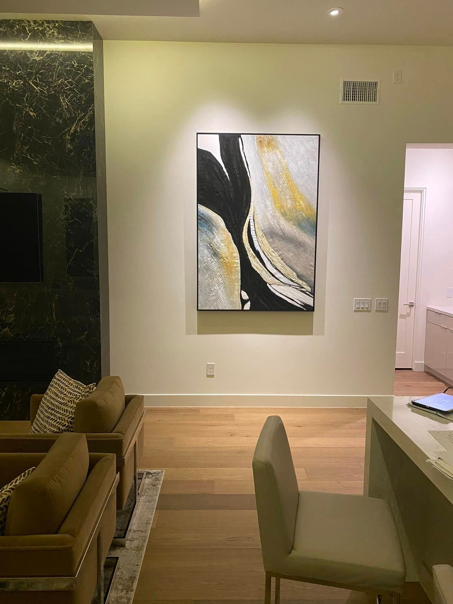 Two-story house with gray siding and garage doors, wet street reflects the evening sky.