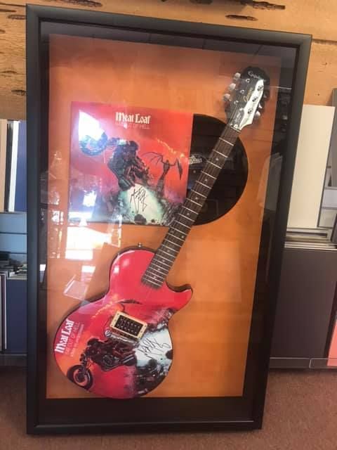 Framed rock and roll display with a red guitar, album, and vinyl record.