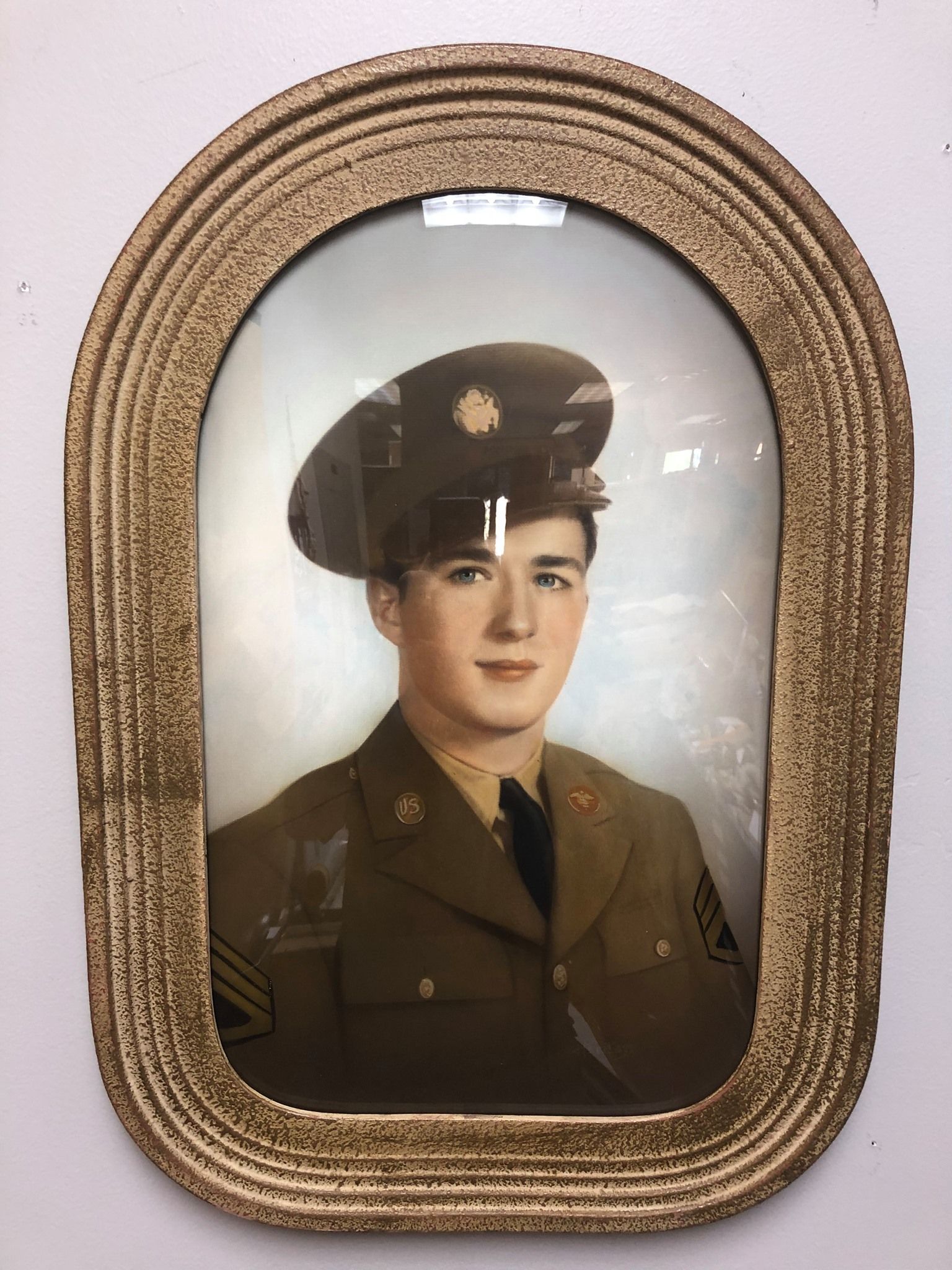 Portrait of a young man in a military uniform, framed in a gold oval.