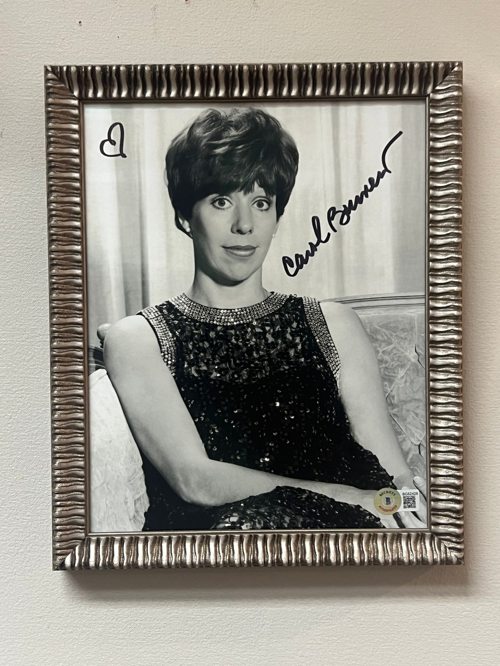Framed black and white photo of Carol Burnett, signed autograph, heart drawn next to signature.
