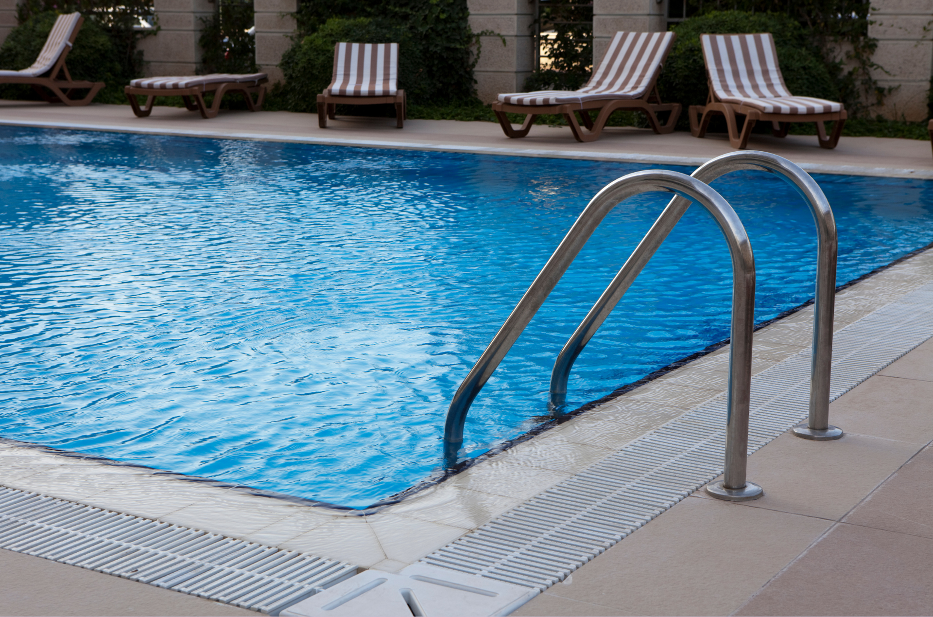 A large swimming pool with a house in the background