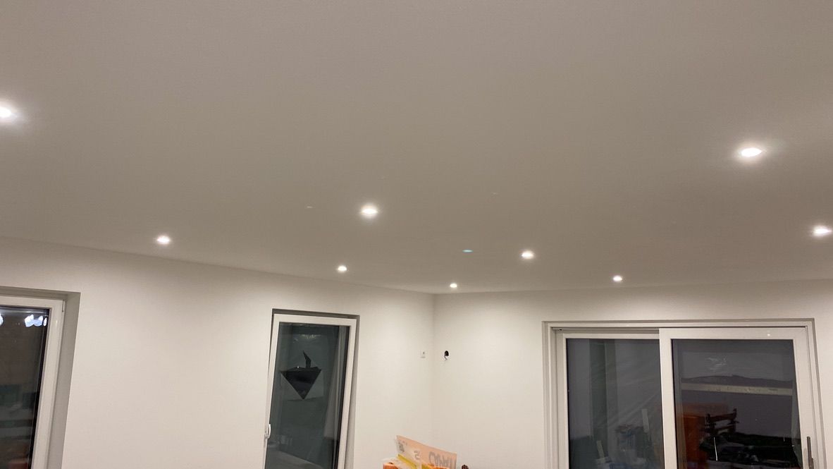 Ein Wohnzimmer mit weißer Decke und Glasschiebetüren.