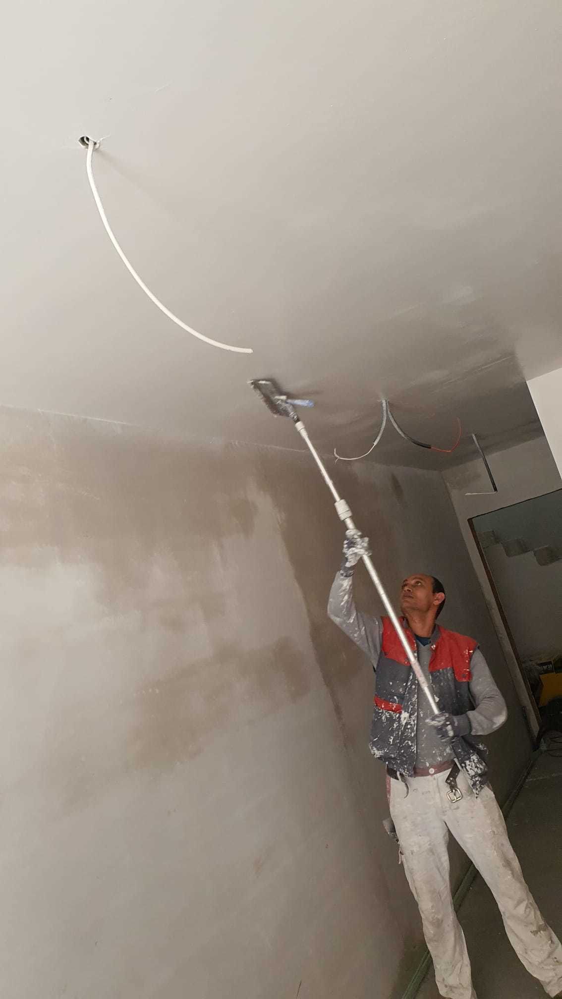 Ein Mann streicht eine Decke mit einer Rolle.