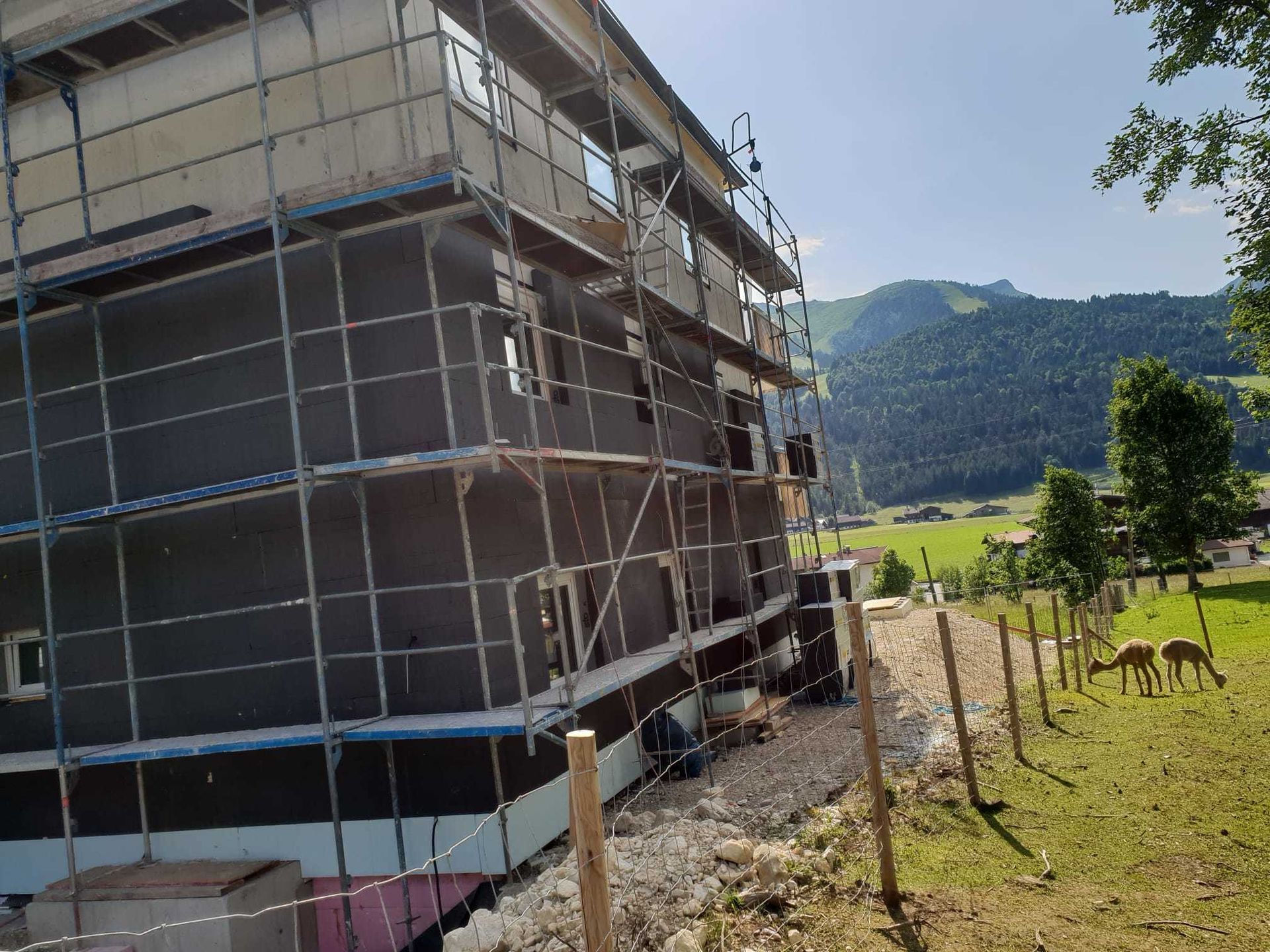 Es wird ein Gebäude errichtet, das von einem Gerüst umgeben ist.