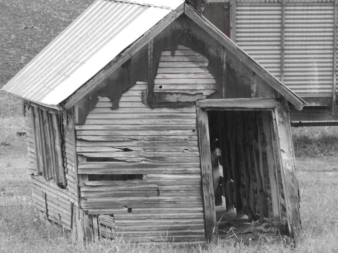 A black and white photo of an old wooden house