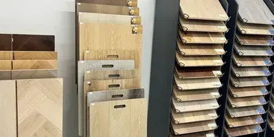 Wood flooring samples in various shades displayed on a rack.