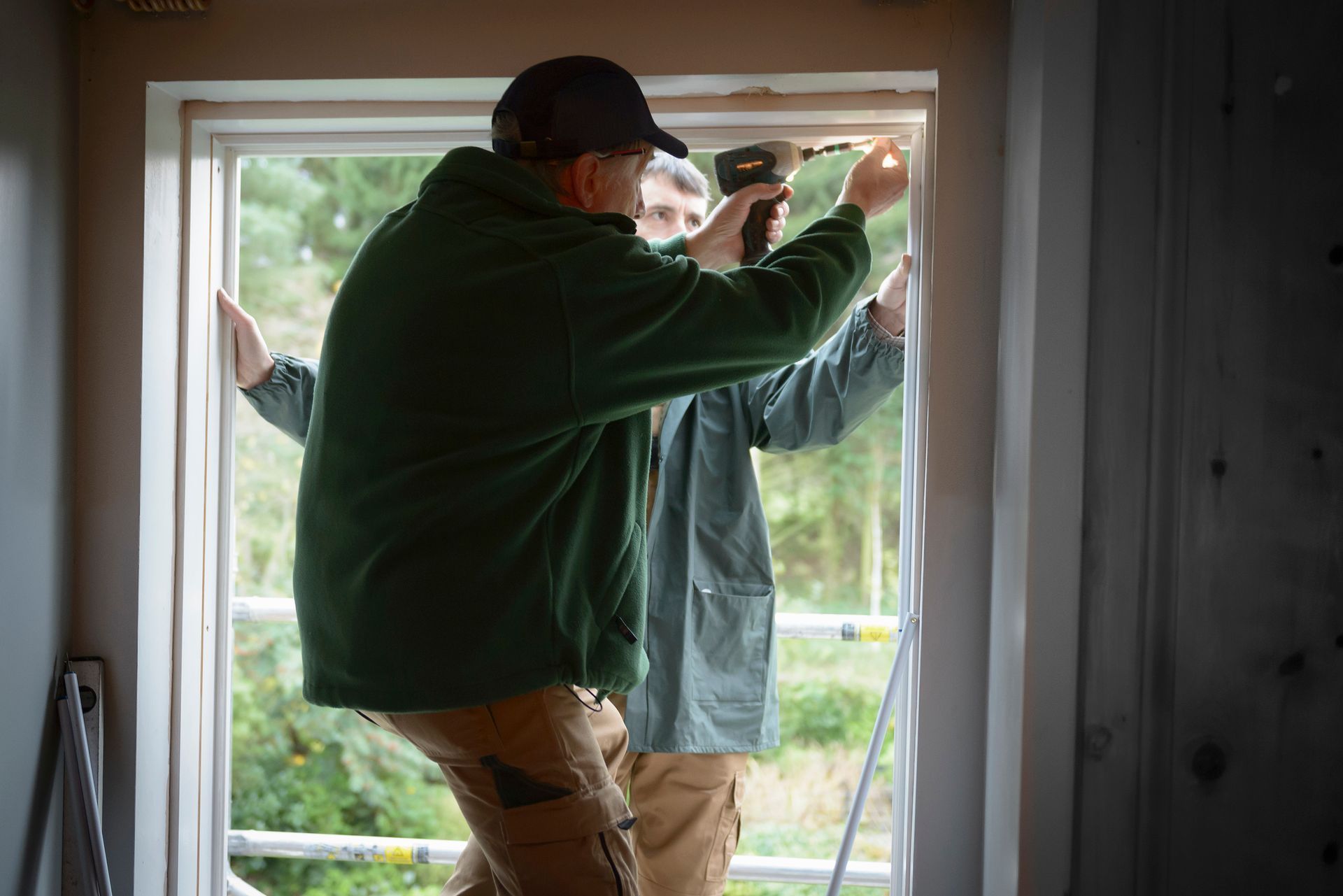 Technicians installing new energy efficient window frame during home improvement project.