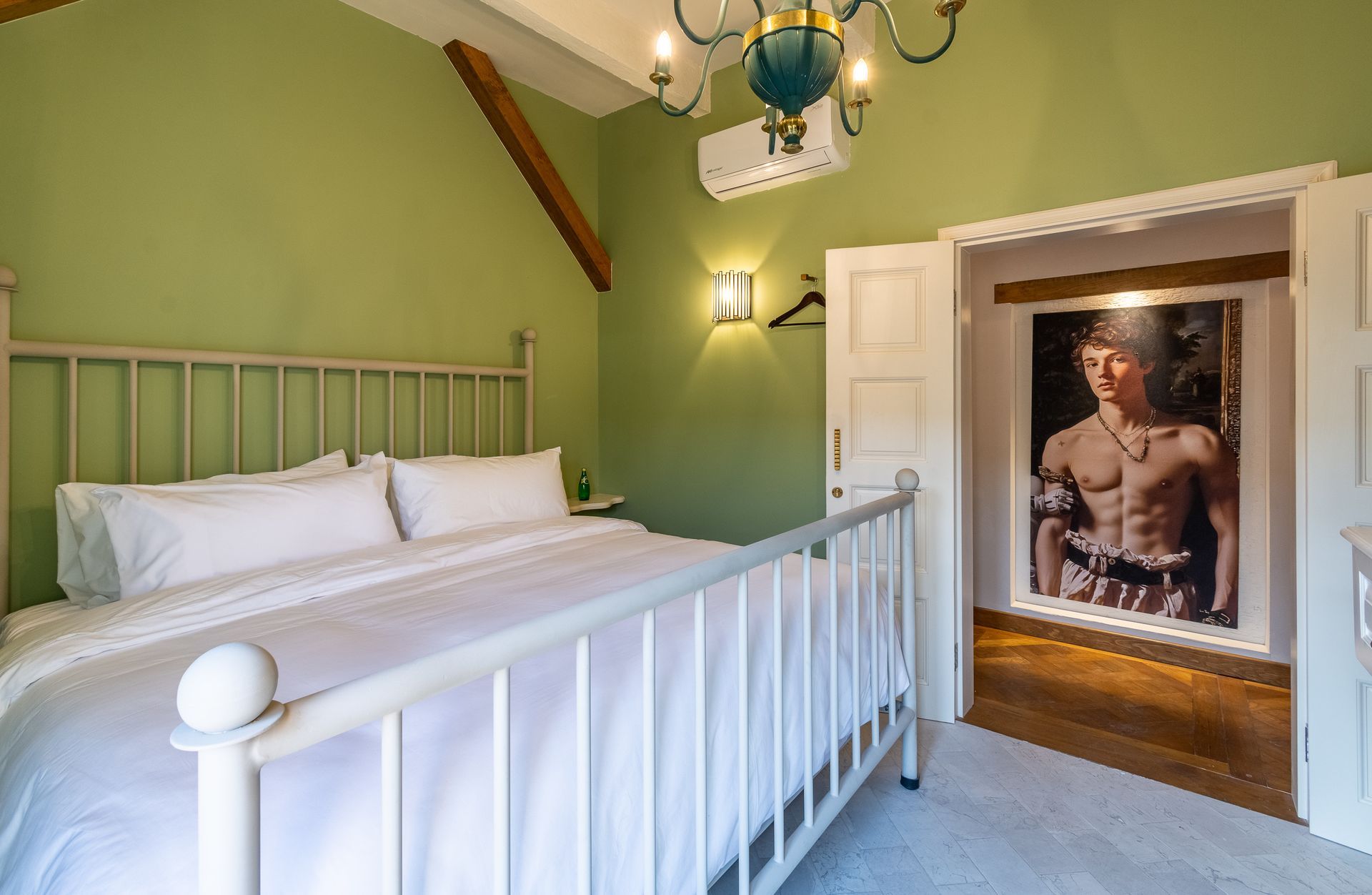 Un dormitorio con una cama y un cuadro en la pared.