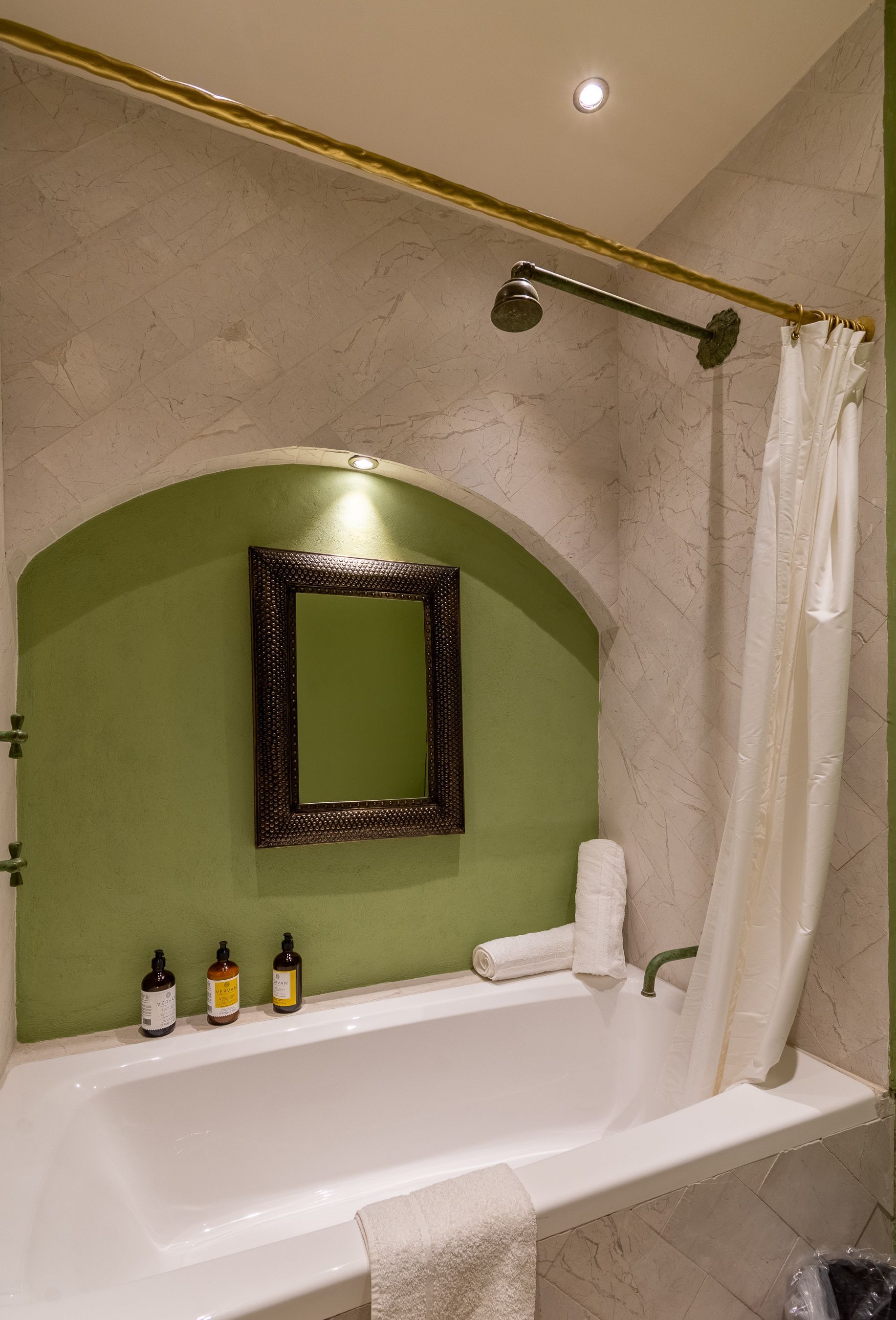 Un baño con bañera, ducha y espejo.
