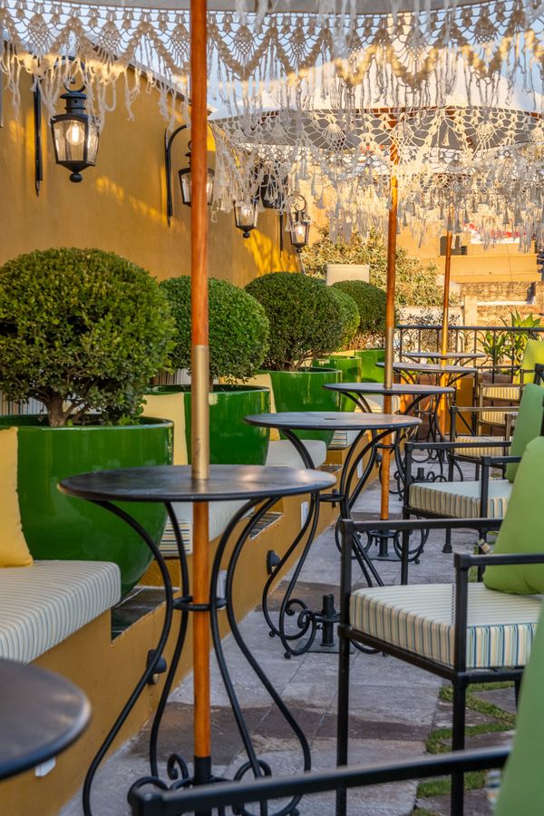 Una fila de mesas y sillas bajo una sombrilla en un restaurante.