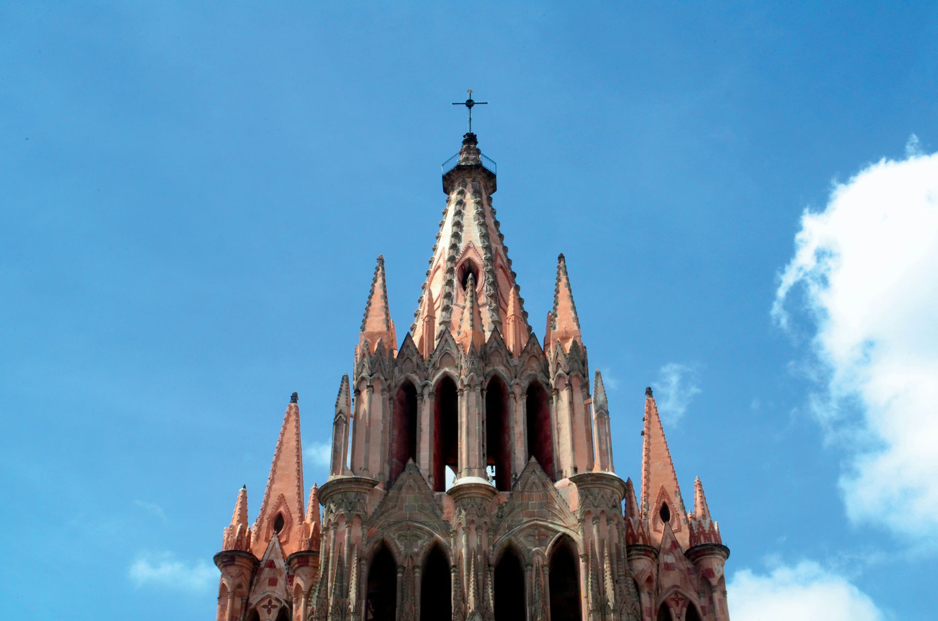 Una iglesia con una cruz encima contra un cielo azul.
