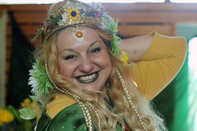 A woman is wearing a crown of flowers on her head and smiling,  Belladonna LaVeau as Demeter.