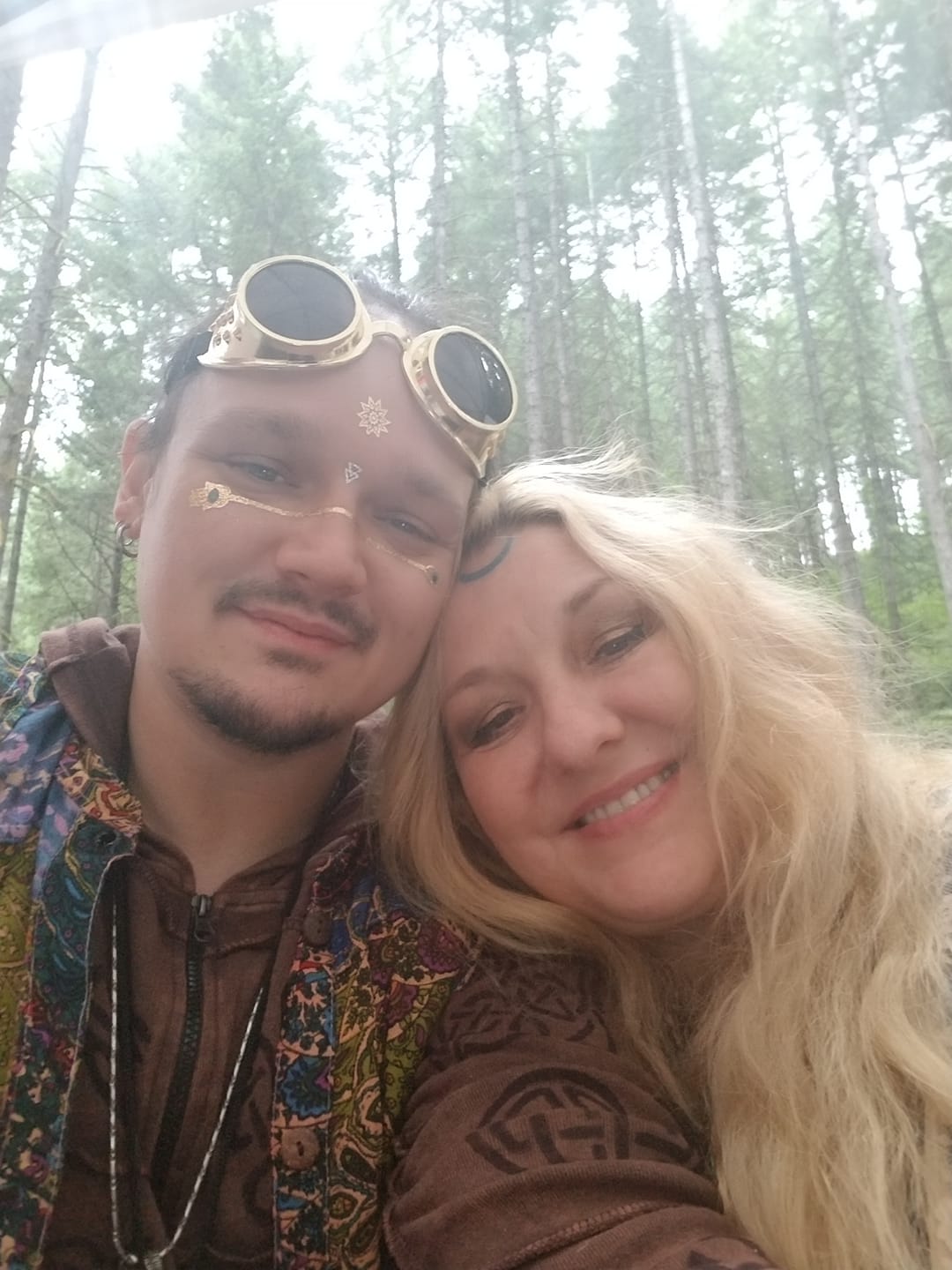 A man and a woman are posing for a picture in the woods, Dusty Dionne and Belladonna LaVeau.