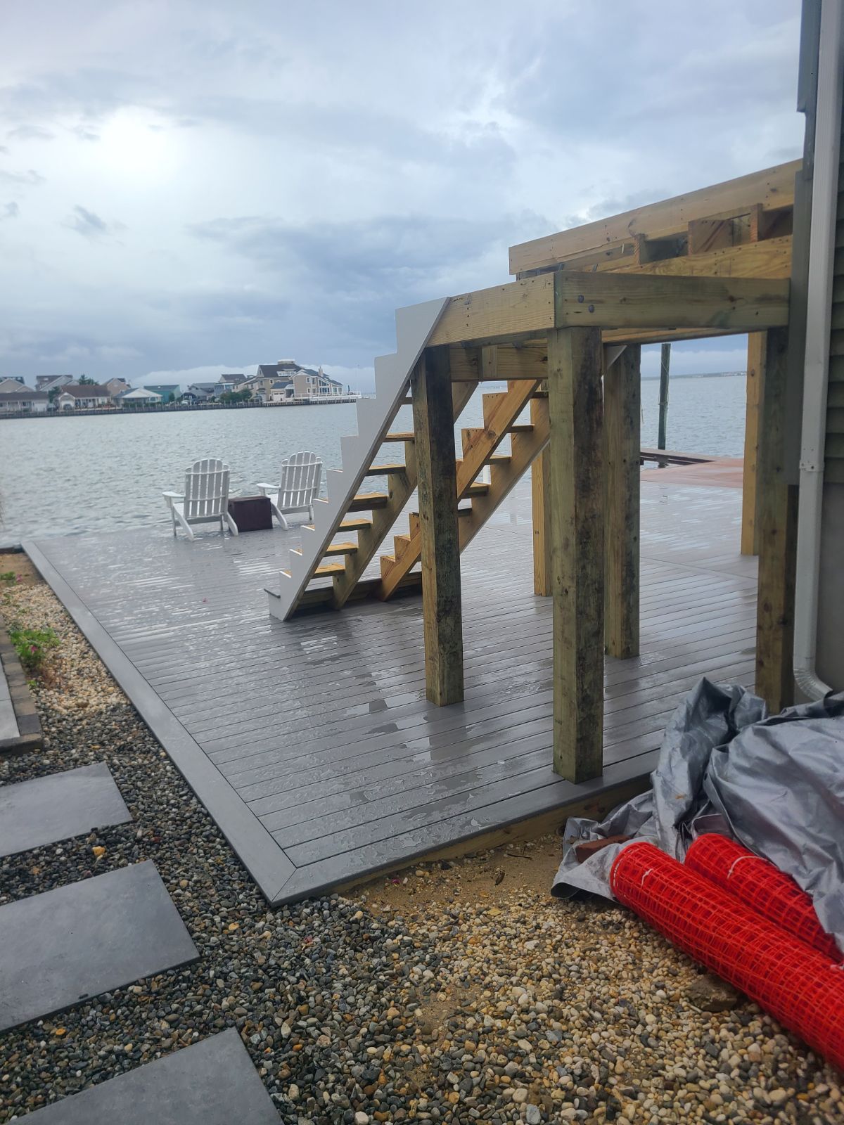 A wooden deck with stairs leading up to the water.