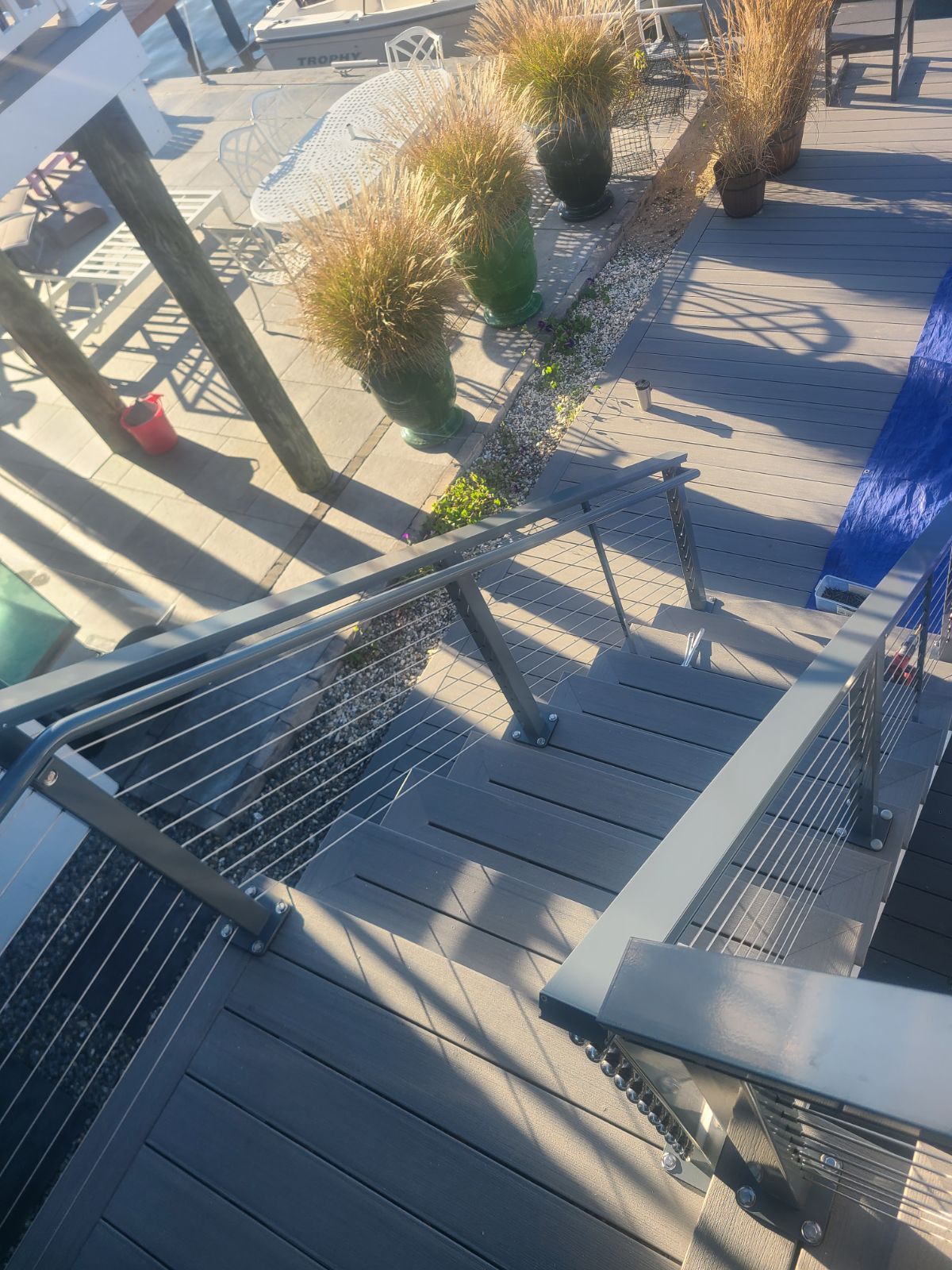 A set of stairs leading up to a deck with a stainless steel railing.