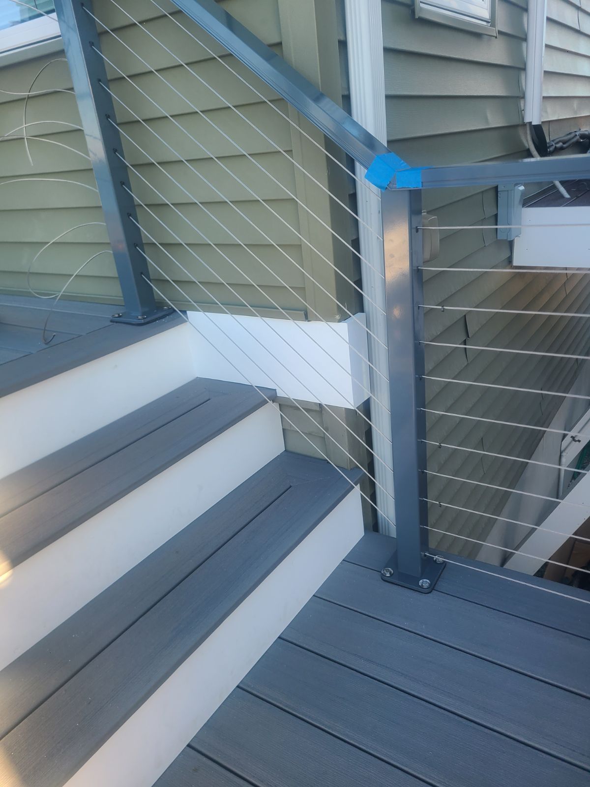 A close up of a deck with stairs and a wire railing