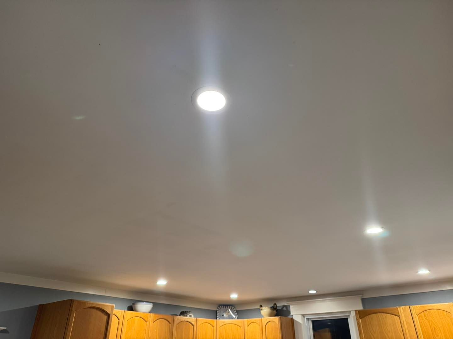 A kitchen with wooden cabinets and a white ceiling.