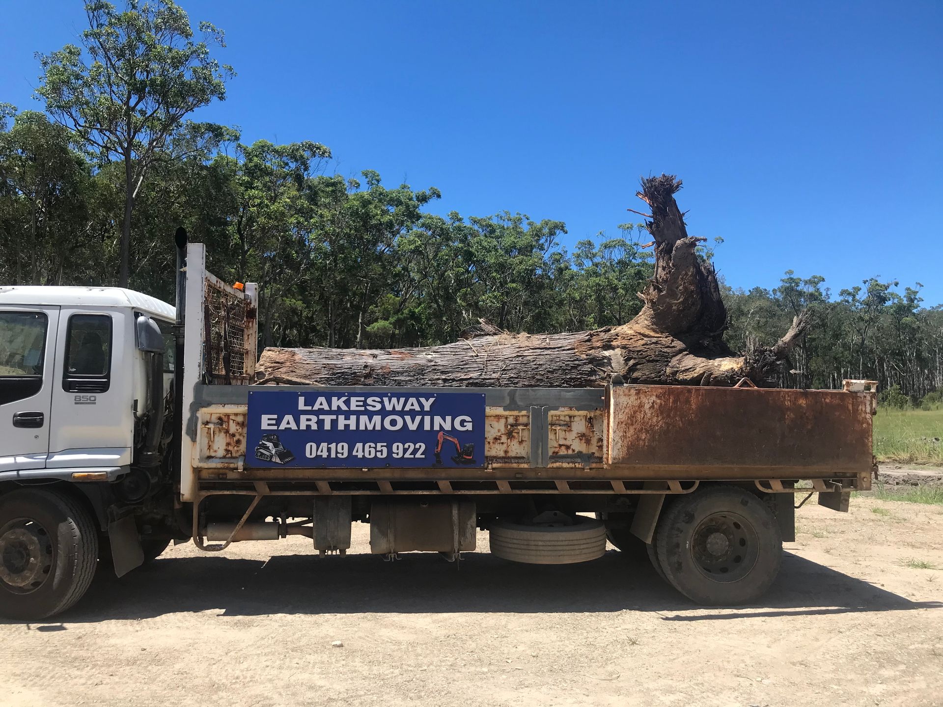 A Large Log is Sitting on the Back of a Dump Truck — Lakesway Earthmoving in Charlotte Bay, NSW