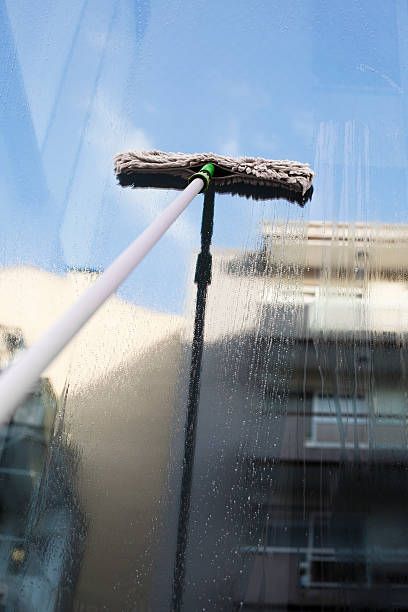 squeegee cleaning a dirty panel window with blue top