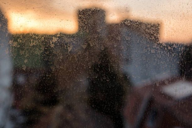 A blurry picture of a person standing in front of a window.