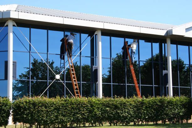 Two men are cleaning the windows of a large building