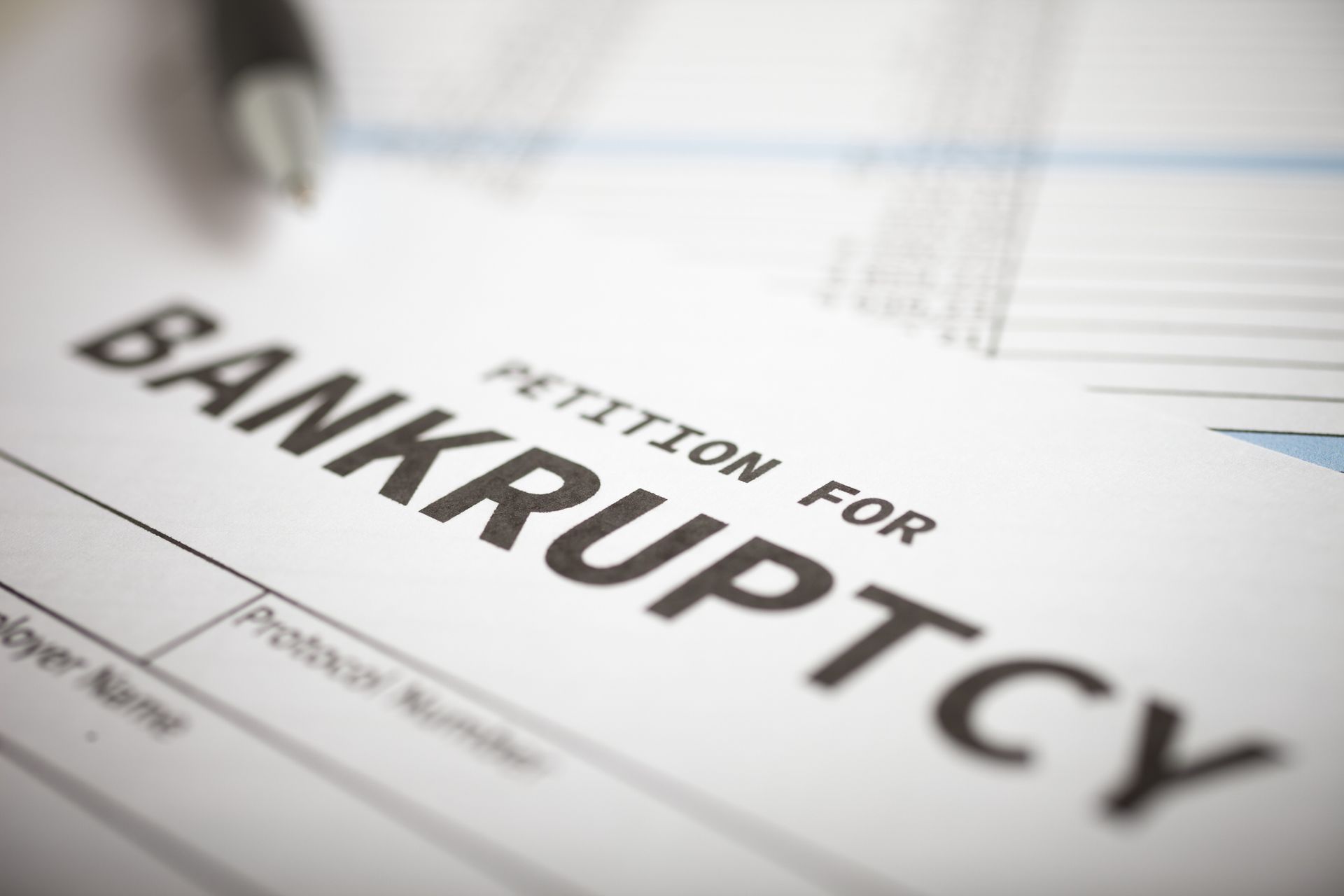 Form titled Petition for Bankruptcy with pen, representing bankruptcy law documentation process.