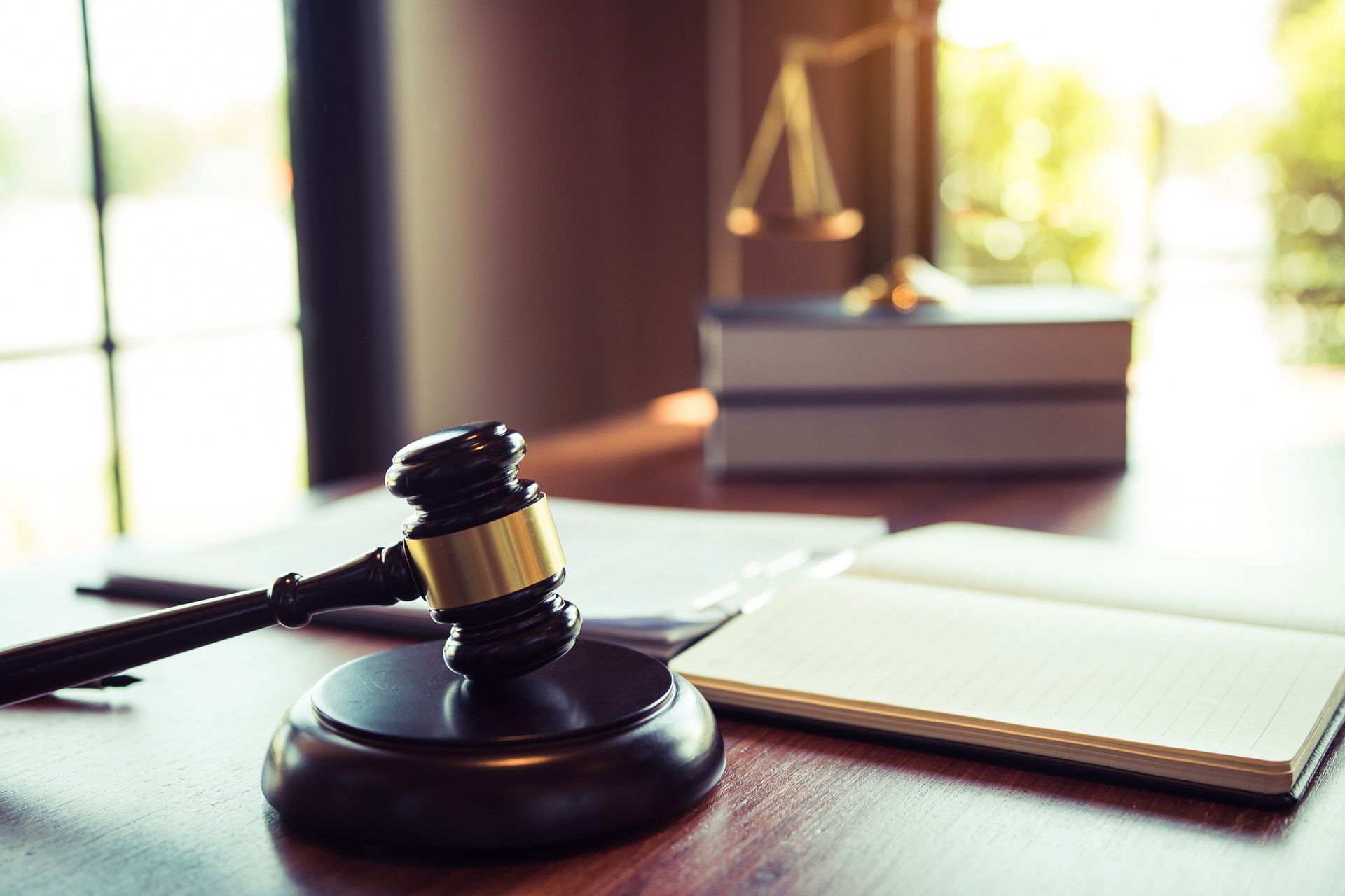 Gavel, law book, and scales on desk symbolizing justice and bankruptcy law legal decisions.
