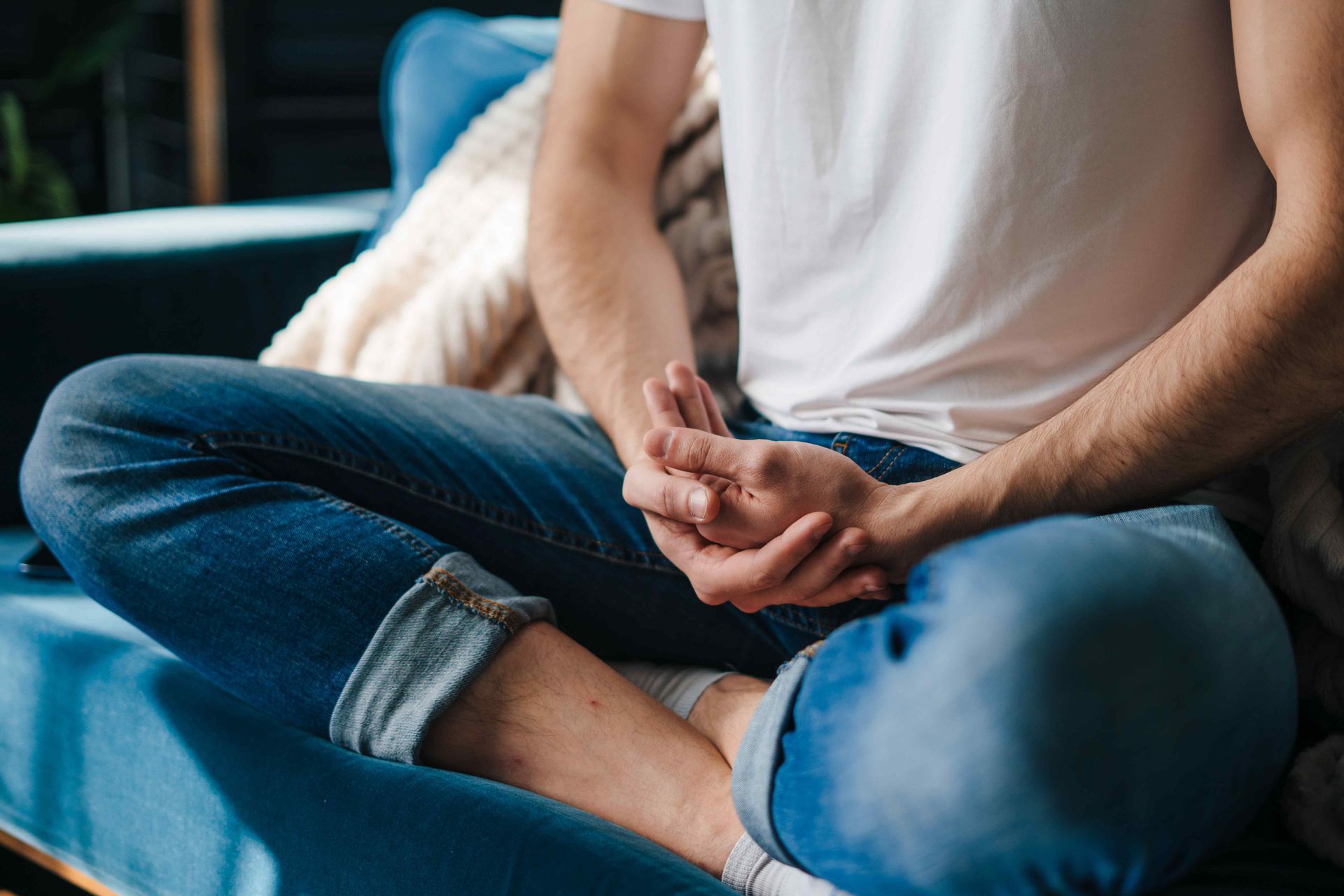 Person sitting with their legs crossed performing a yoga pose.