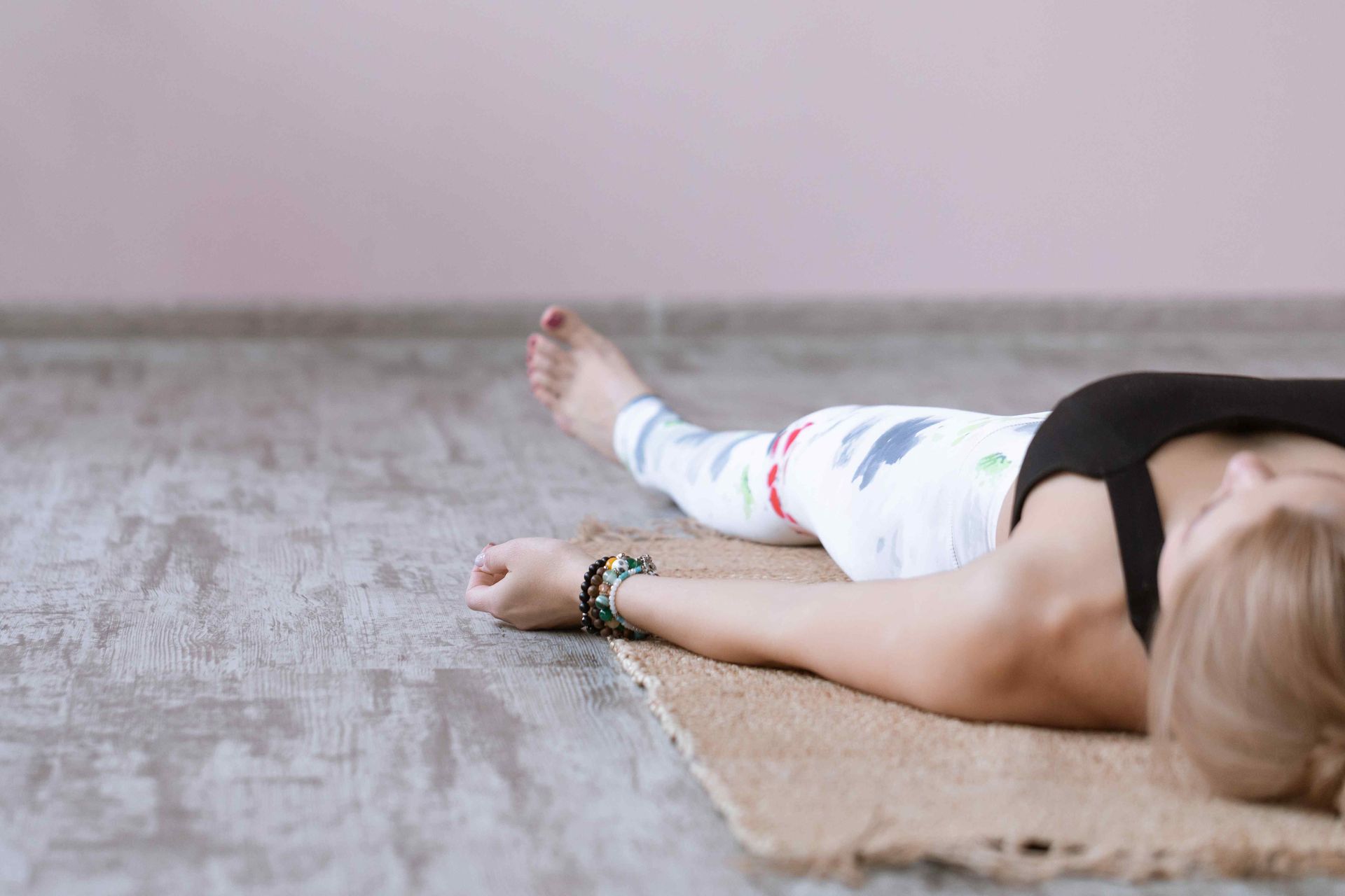 Woman lying on a mat performing yoga nidra