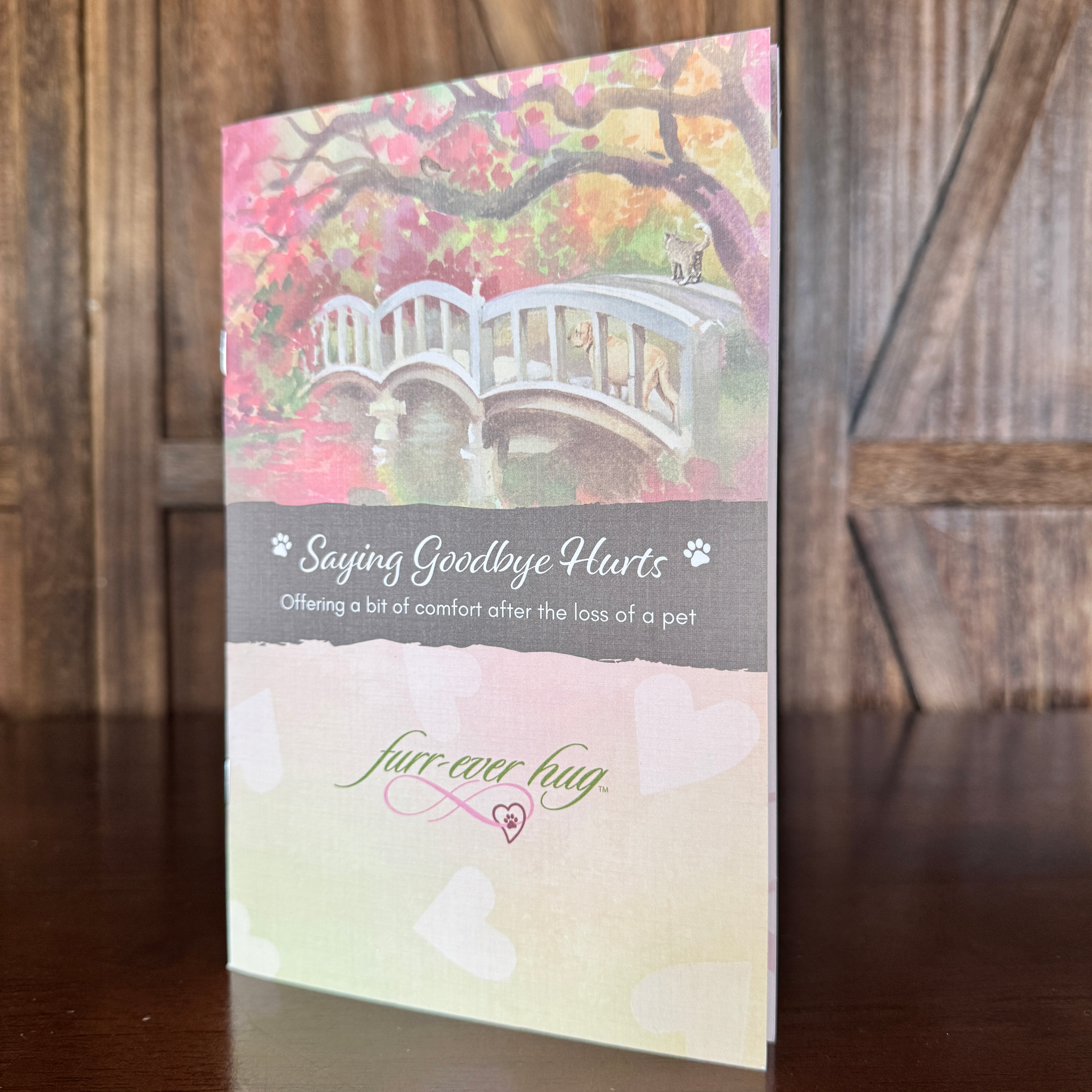 Booklet with watercolor of a bridge in a park. Text says, 