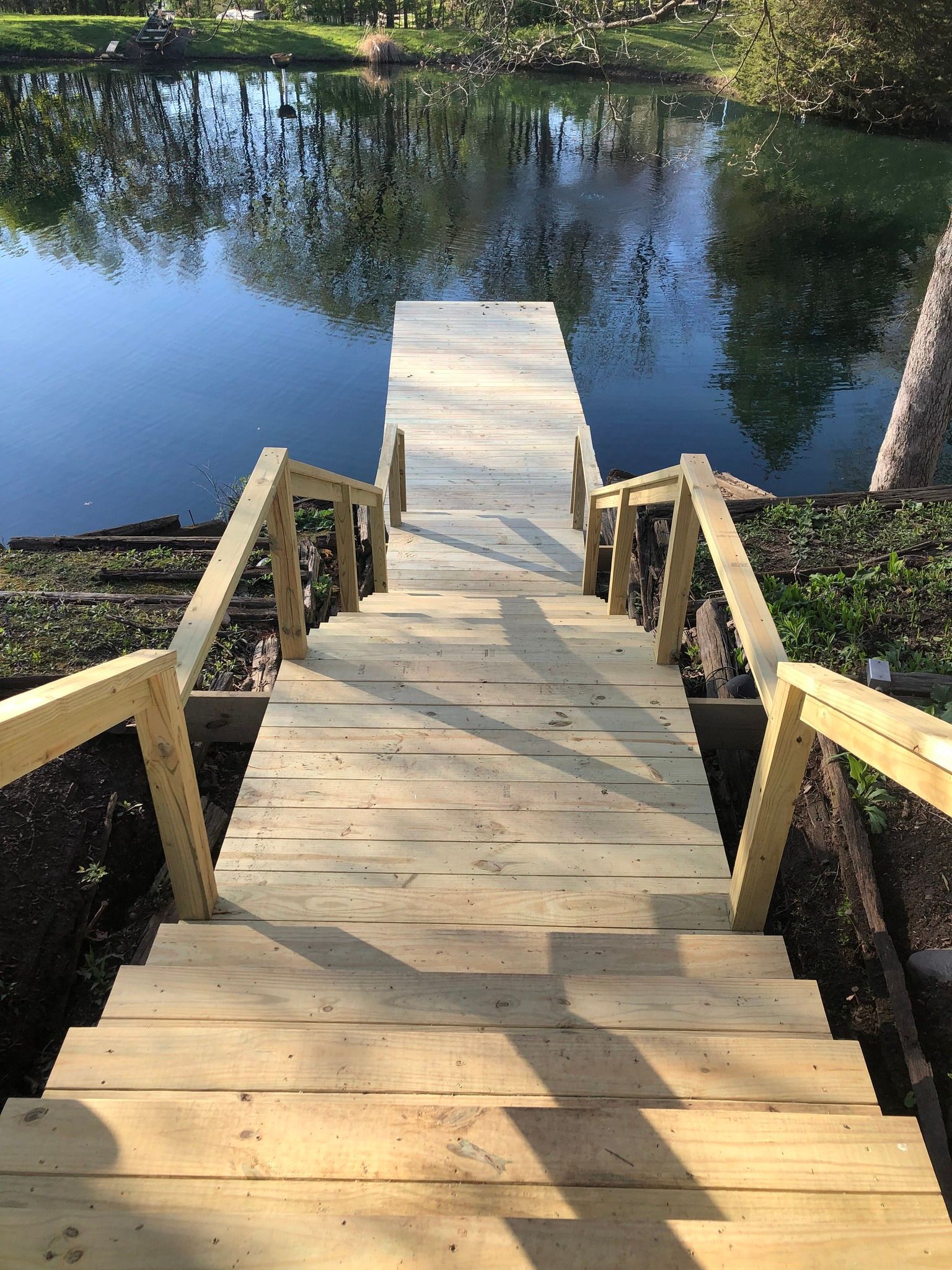A wooden dock with stairs leading to a body of water.