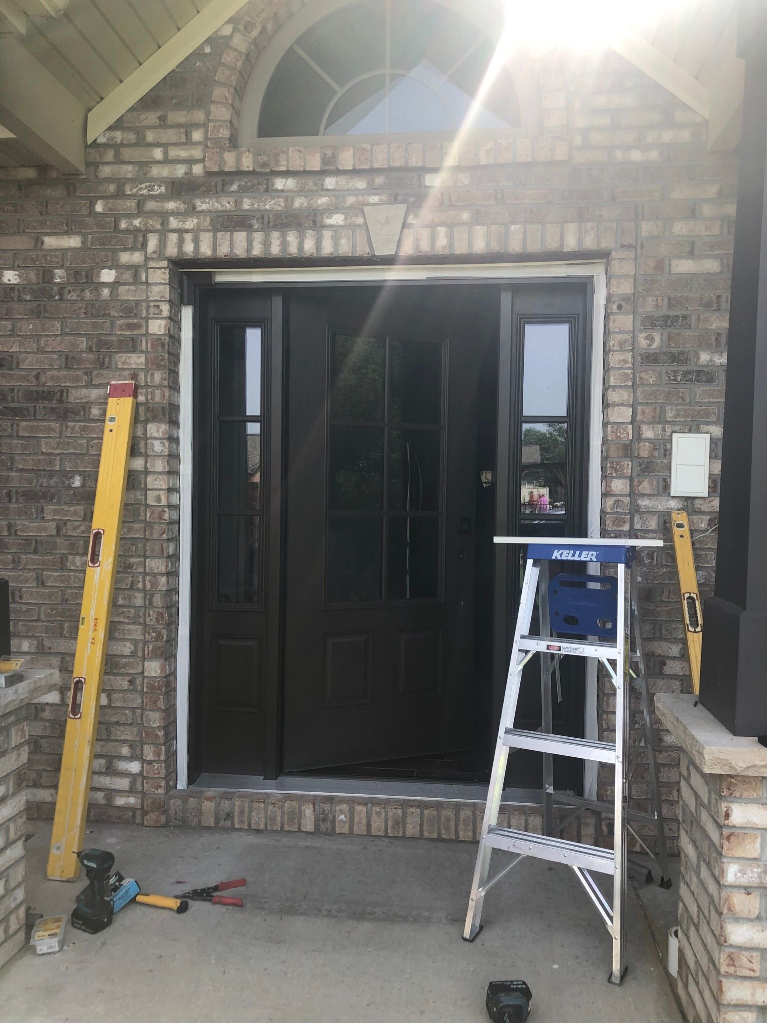 A ladder is sitting in front of a brick door.