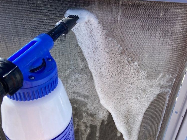 a spray bottle is being used to clean an air conditioner