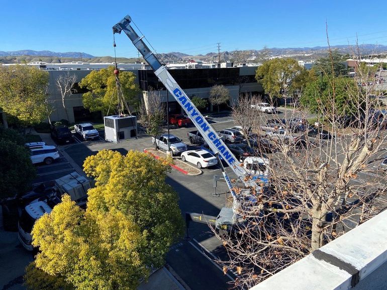 a canyon crane is lifting something in a parking lot