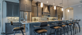 A kitchen with a long island and bar stools.