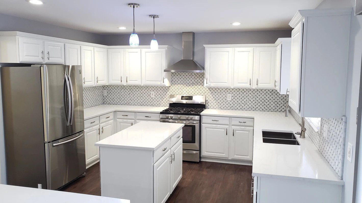 A kitchen with white cabinets and stainless steel appliances