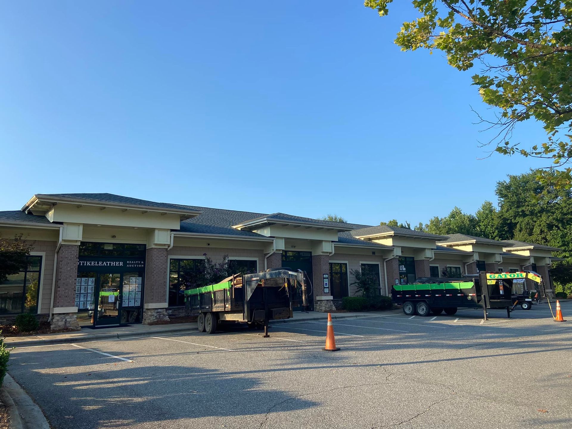 A green truck is parked in front of a building.
